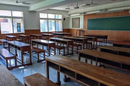 A BMSCE classroom with wooden benches and a green board
